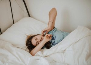 Woman in bed stretching after high quality sleep